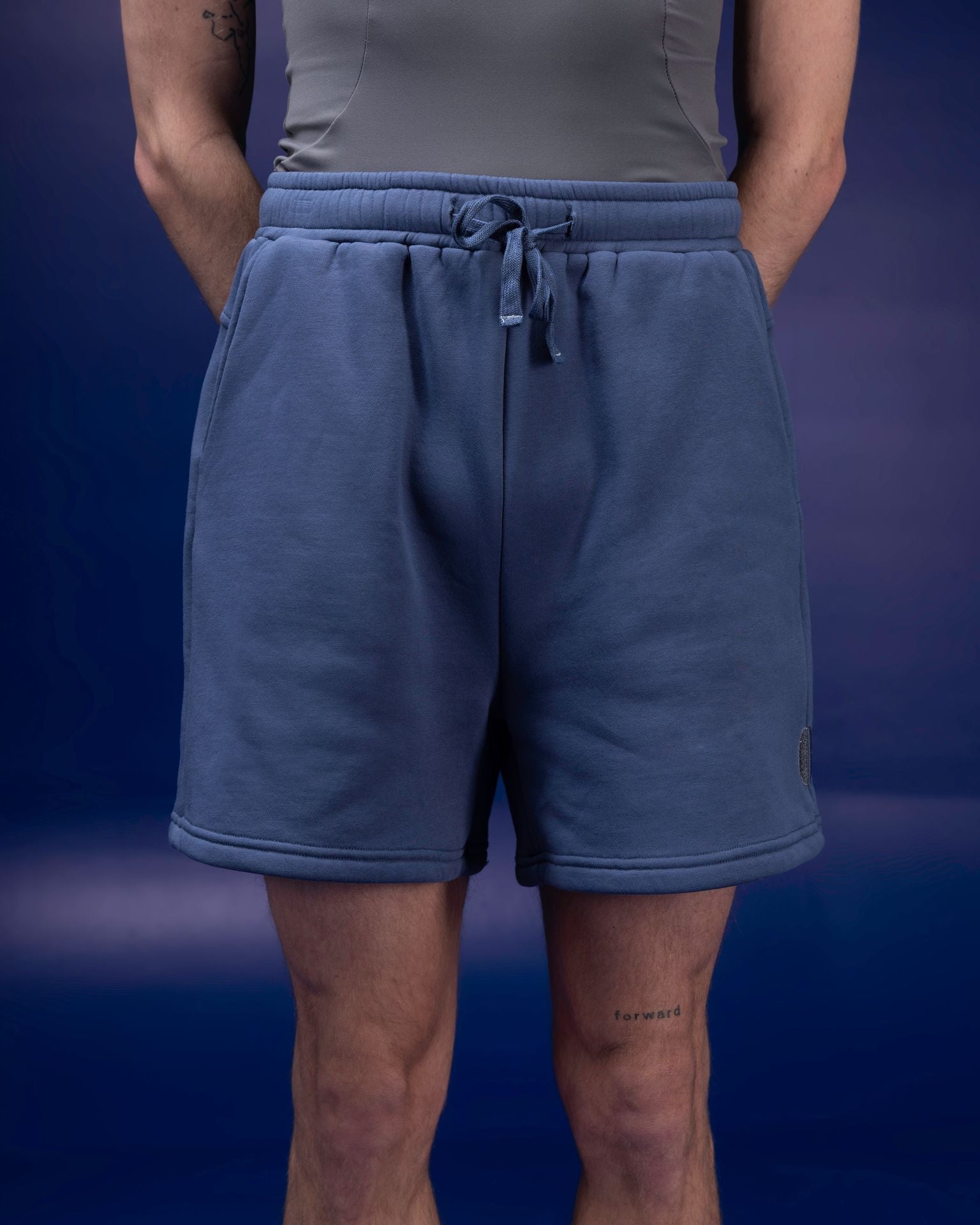 Male dancer wearing male dancewear blue warm up shorts